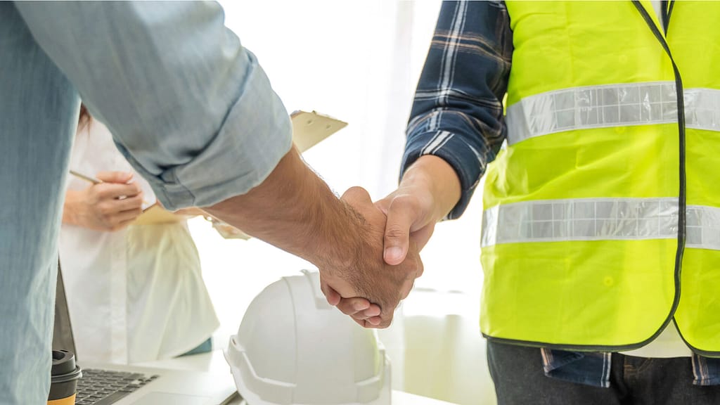 A contractor and a person shaking hands to close a deal