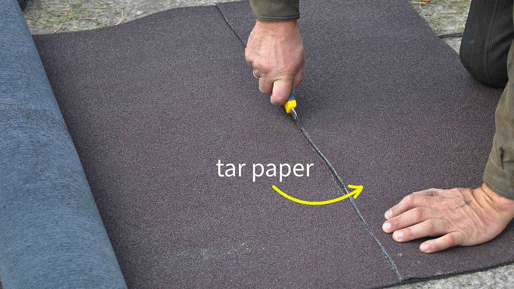Roofer cutting tar paper