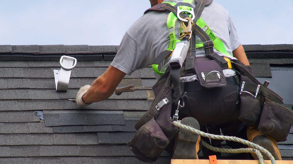 Roofer removing shingle